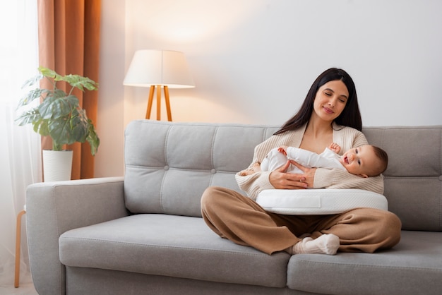 Volle Schussmutter, die neugeborenes Baby hält