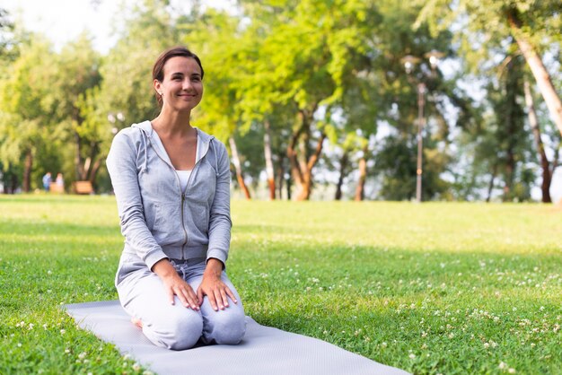 Volle Schusssmileyfrau auf Yogamatte