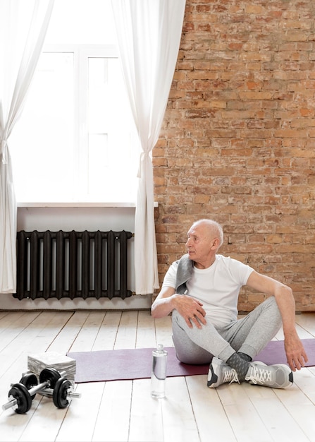 Kostenloses Foto voller schuss älterer mann auf yogamatte