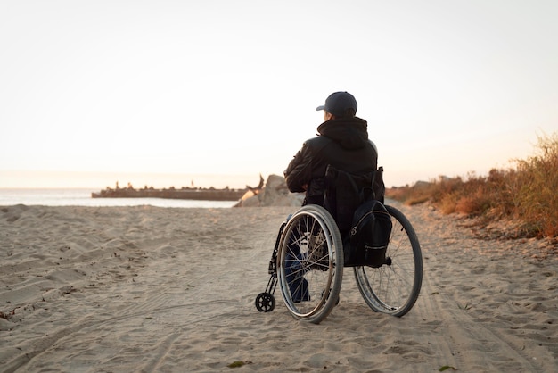 Kostenloses Foto voller schuss behinderter mann am strand