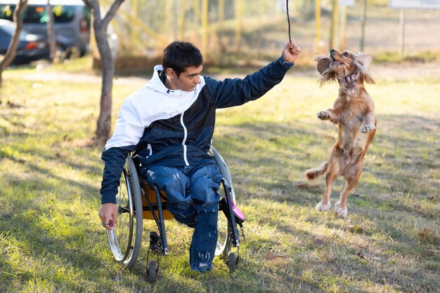 Voller Schuss behinderter Mann, der mit Hund spielt