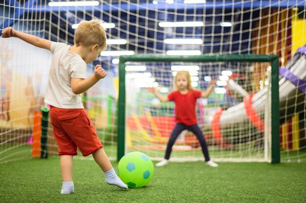 Voller Schuss des Jungen Ball tretend