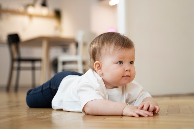 Voller Schuss entzückendes Baby, das auf dem Boden liegt