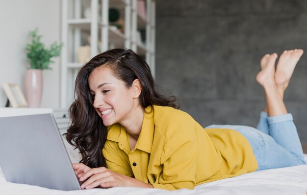 Voller Schuss glückliche Brunettefrau mit Laptop