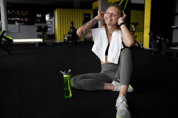 Voller Schuss glückliche Frau im Fitnessstudio