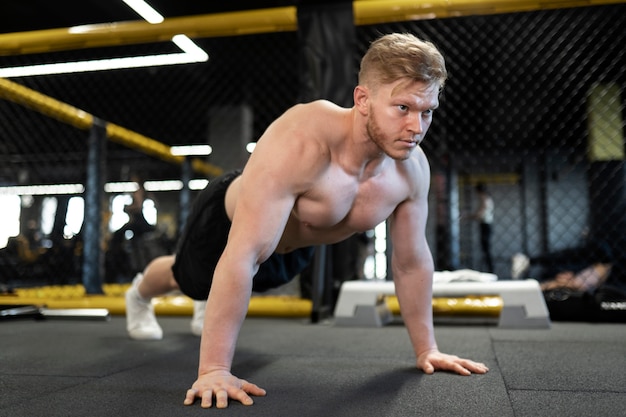 Voller Schuss hemdloser Mann beim Training im Fitnessstudio