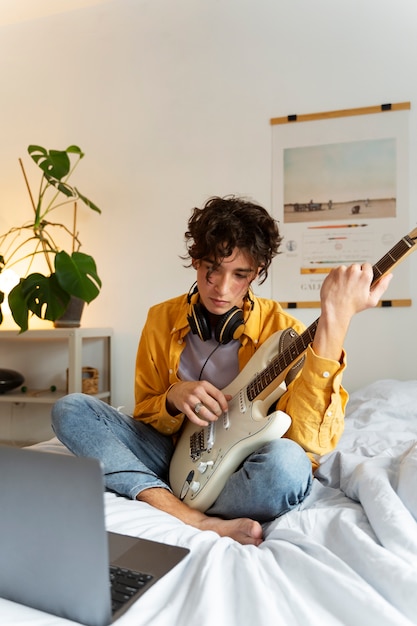 Kostenloses Foto voller schuss junge, der drinnen musik macht