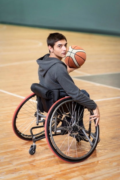 Voller Schuss junger behinderter Mann, der Ball hält