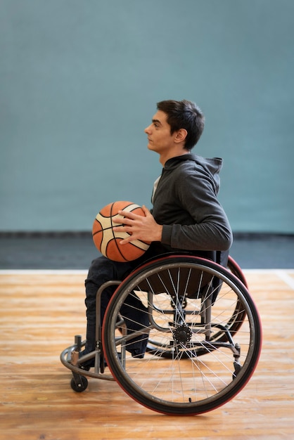 Voller Schuss junger behinderter Mann, der Basketball hält