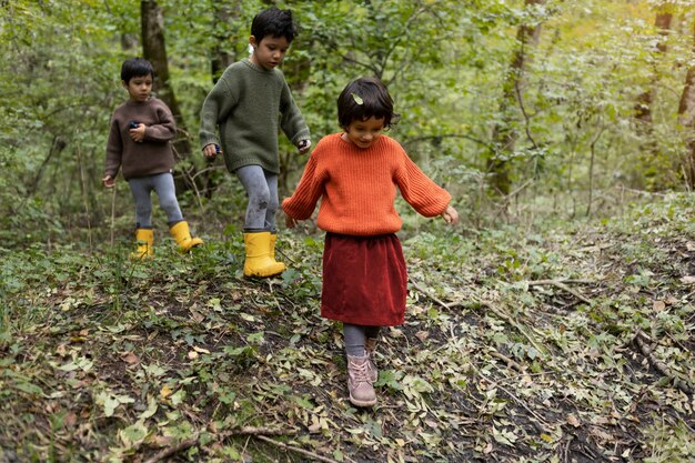 Voller Schuss Kinder, die in der Natur spazieren gehen