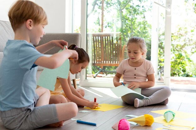 Voller Schuss Kinder, die mit Papier kreativ sind