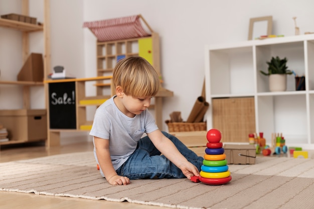 Voller Schuss kleines Kind, das mit Holzspielzeug spielt