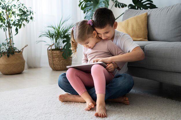 Voller Schuss Mädchen und Junge mit Tablette