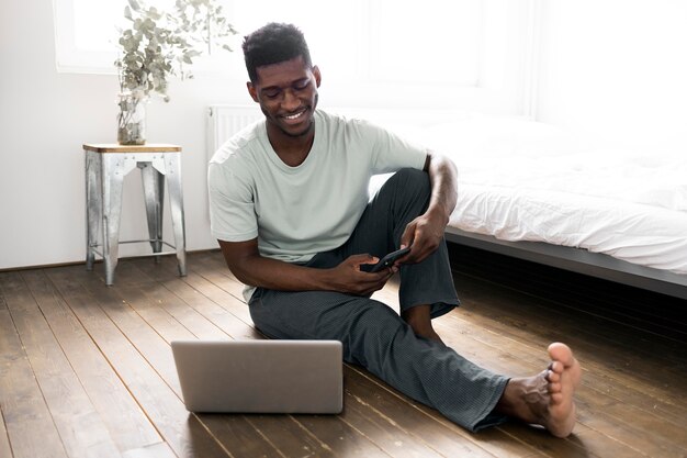 Voller Schuss Mann auf dem Boden mit Laptop