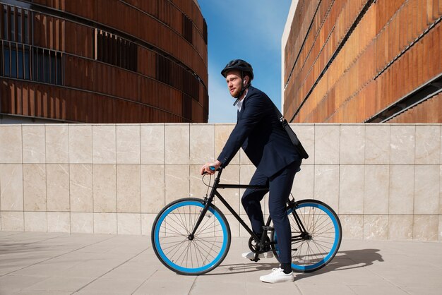 Voller Schuss Mann auf dem Fahrrad, der zur Arbeit geht