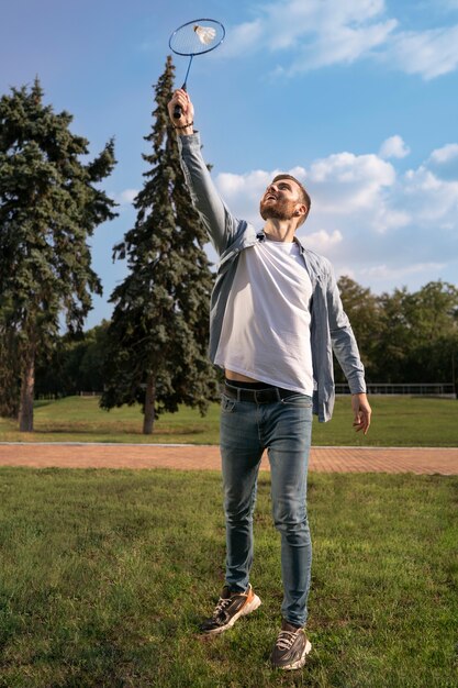 Voller schuss mann, der badminton spielt