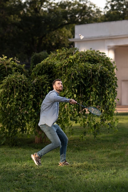 Voller Schuss Mann, der Badminton spielt