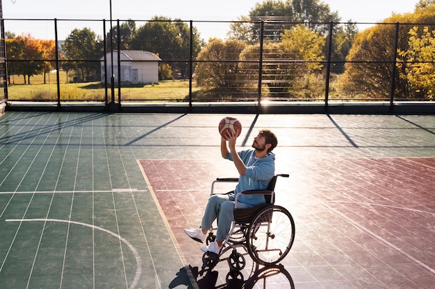 Kostenloses Foto voller schuss mann, der draußen basketball spielt