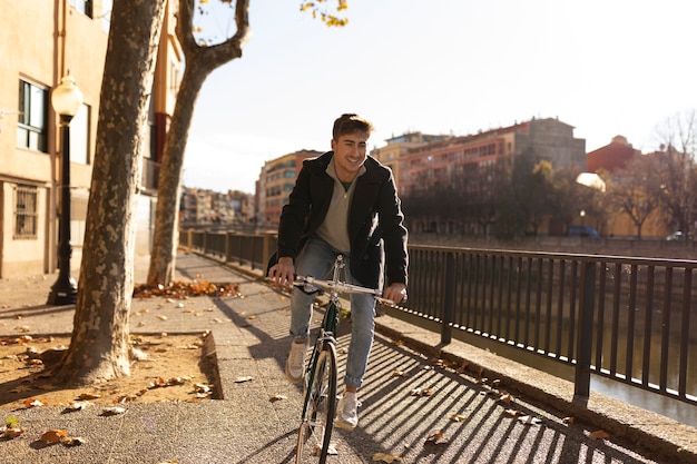 Kostenloses Foto voller schuss mann, der draußen fahrrad fährt