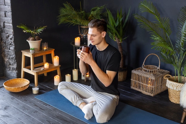 Kostenloses Foto voller schuss mann, der drinnen yoga macht