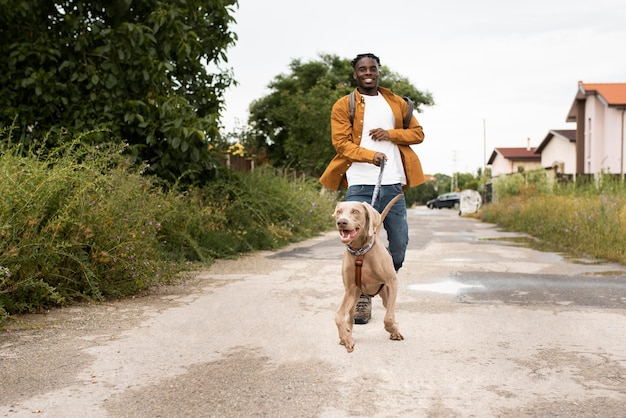 Voller Schuss Mann, der mit Hund geht