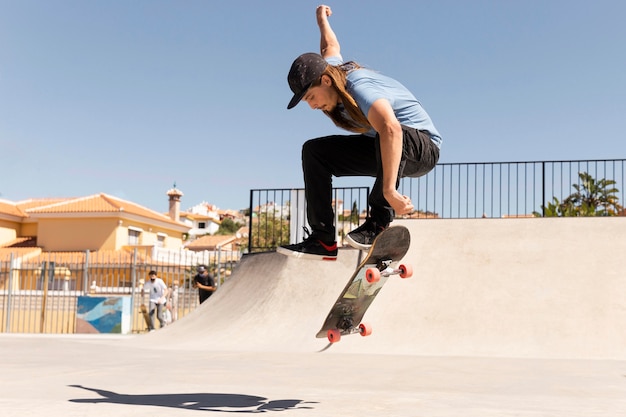 Voller Schuss Mann macht Tricks mit Skateboard skate