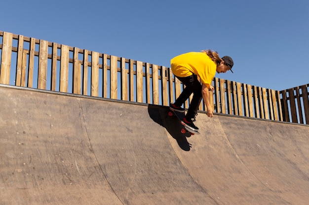 Voller Schuss Mann mit Skateboard springen