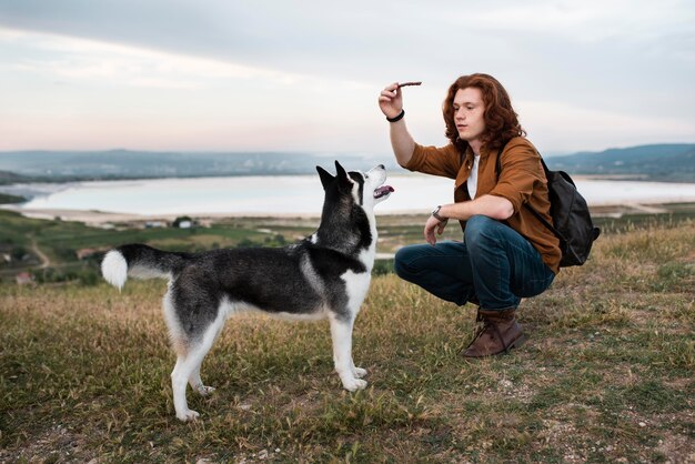 Voller Schuss Mann spielt mit Hund