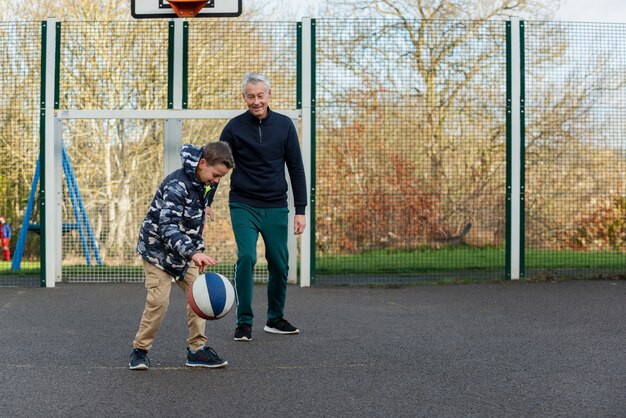Voller Schuss Opa und Kind spielen Basketball