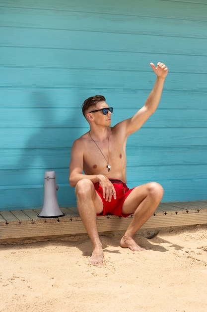 Voller Schuss Rettungsschwimmer am Strand sitzen