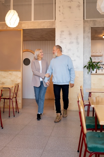 Voller Schuss Smiley älteres Paar Händchen haltend