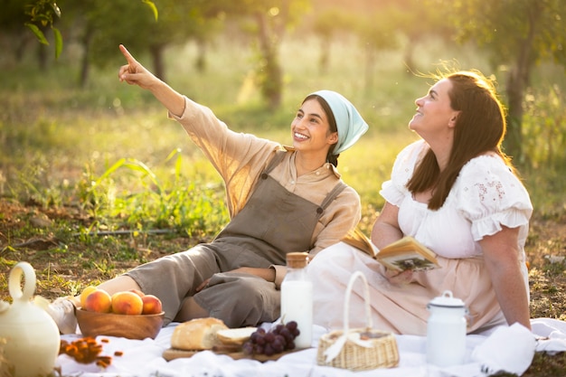 Voller Schuss Smiley-Frauen beim Picknick