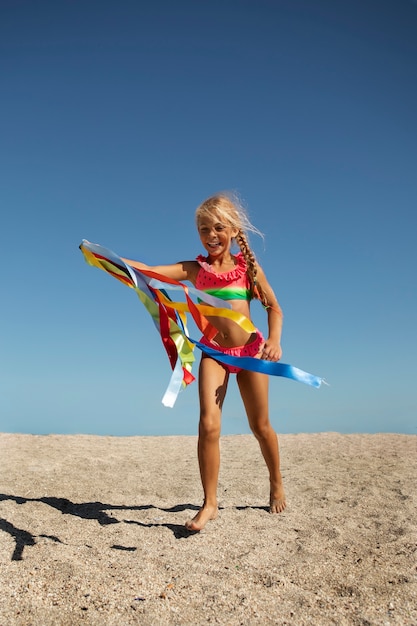 Kostenloses Foto voller schuss smiley-mädchen am strand