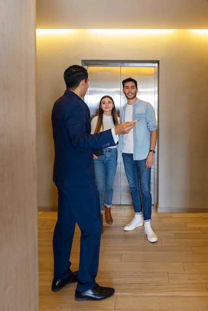 Volles Bild von einem Paar, das mit einem Immobilienmakler spricht
