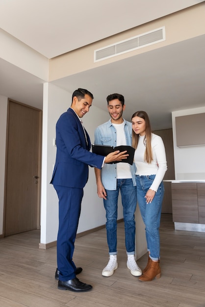 Volles Bild von einem Paar, das mit einem Immobilienmakler spricht