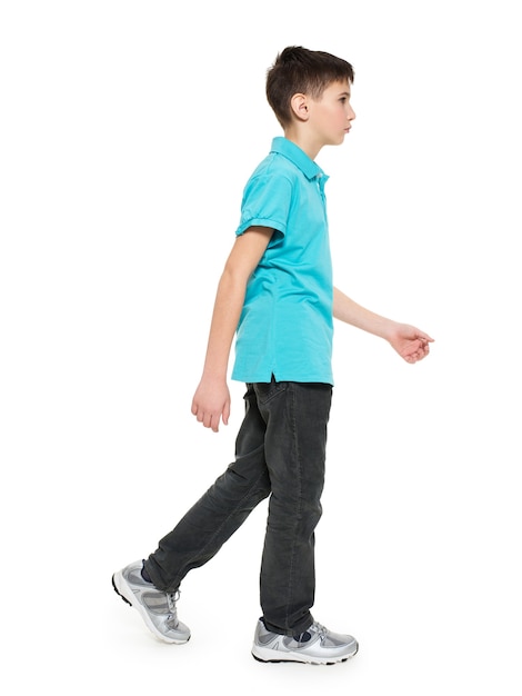 Volles Porträt des gehenden jugendlich Jungen im blauen T-Shirt lässig auf weiß isoliert.