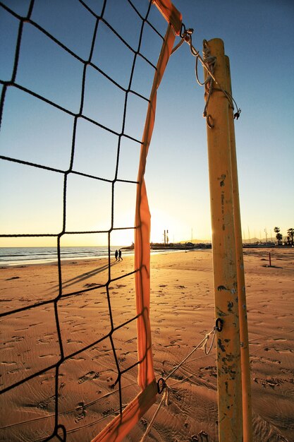 Volleyballnetz am Strand und der Sonnenuntergang im verschwommenen Hintergrund