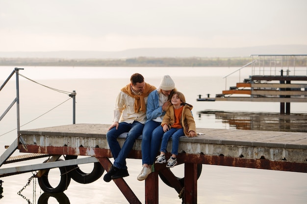 Vollfotografierte Familie, die auf einem Steg herumhängt