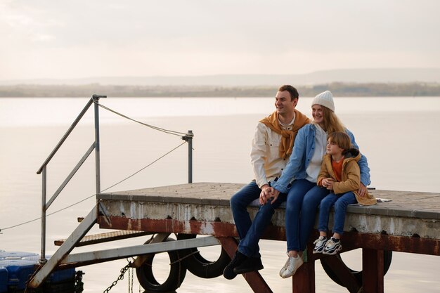 Vollfotografierte Familie, die auf einem Steg herumhängt