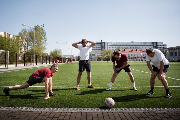 Vollgeschossene Männer strecken sich vor dem Spiel