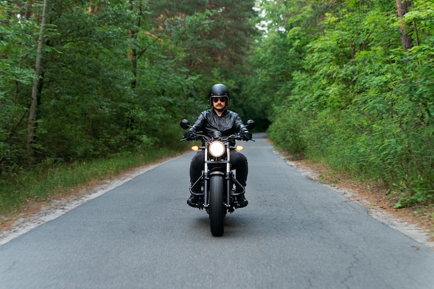 Vollgeschossener Mann mit Motorrad im Freien