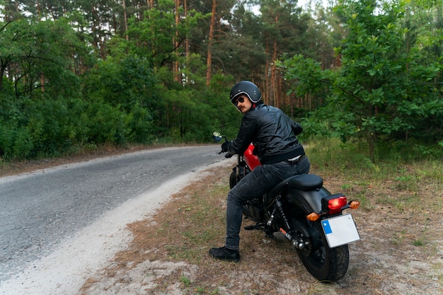 Vollgeschossener Mann mit Motorrad im Freien