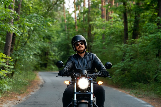 Kostenloses Foto vollgeschossener mann mit motorrad im freien