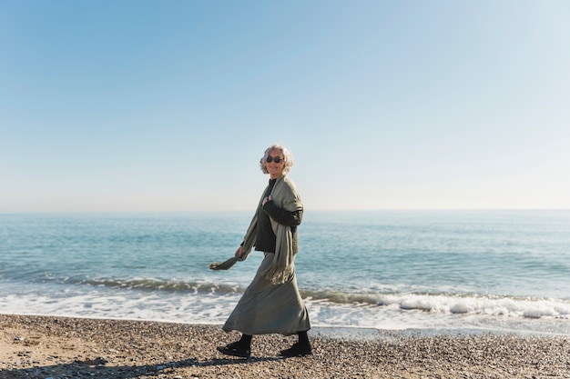 Vollschuss Frau, die auf dem Strand geht