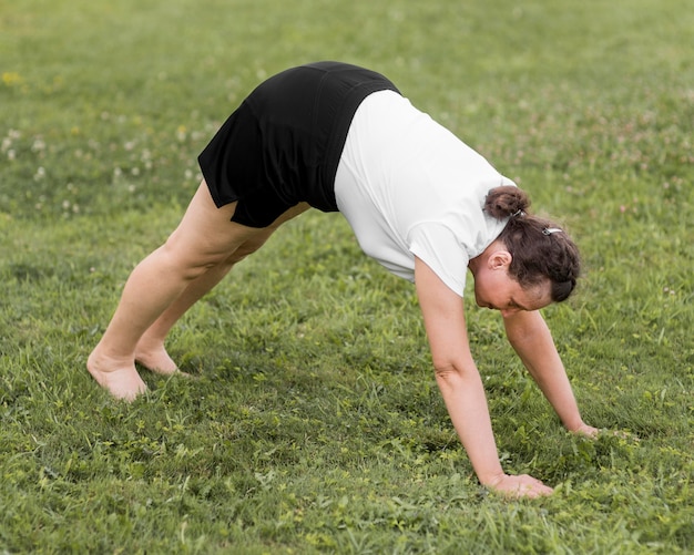 Kostenloses Foto vollschuss frau, die auf gras streckt