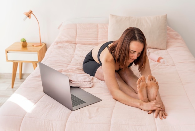 Vollschuss Frau, die sich im Bett ausdehnt