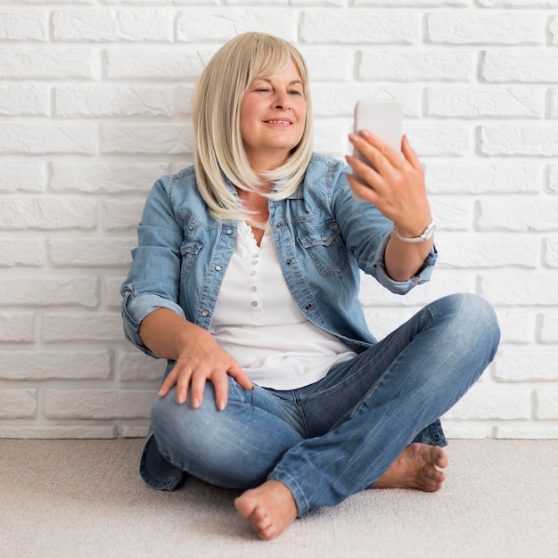 Kostenloses Foto vollschuss frau, die telefon ansieht