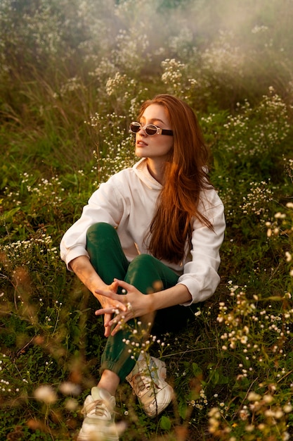 Kostenloses Foto vollschuss frau sitzt auf gras