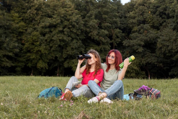 Vollschuss Frauen mit Fernglas auf Gras stehen