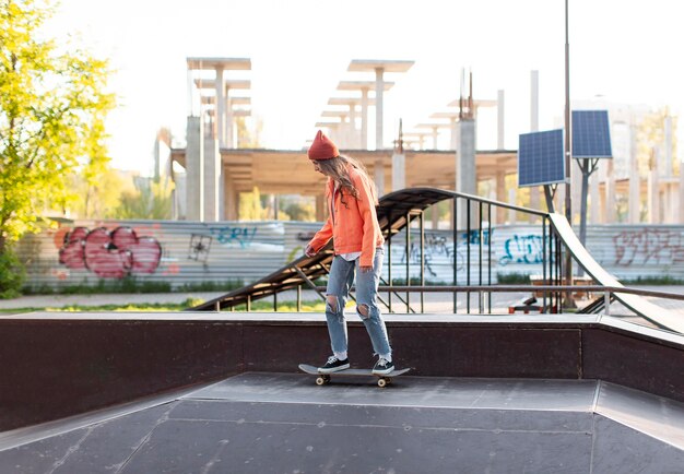 Vollschuss junges Mädchen auf Skateboard draußen